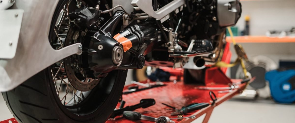 custom-motorcycle-standing-repair-shop-scaled.jpg